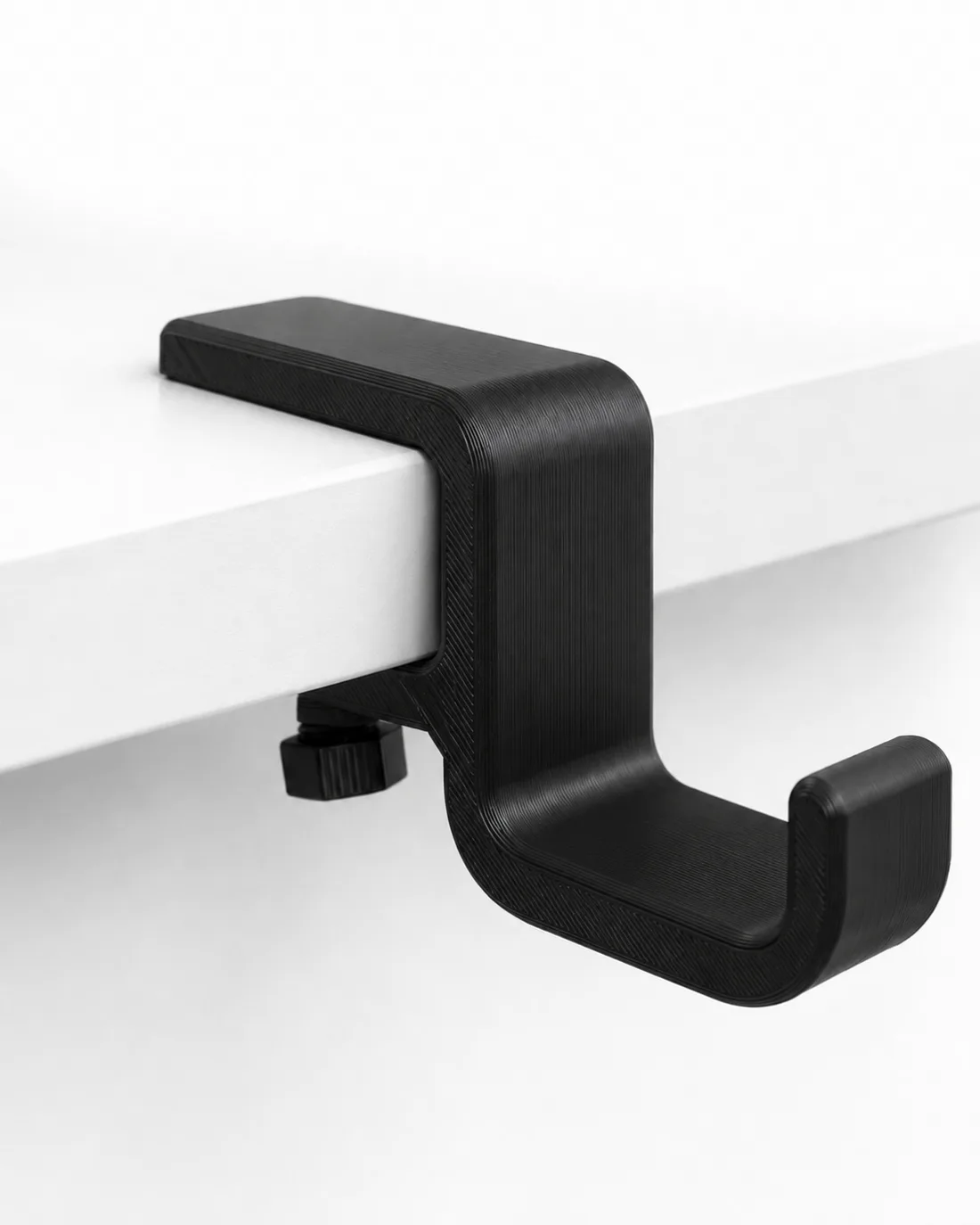 Suporte de fone de ouvido preto fixado na lateral da mesa