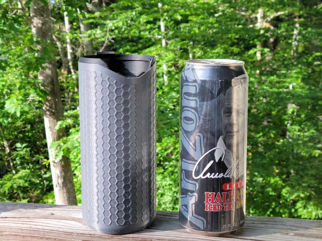 Porta-lata térmico PopTop Koozie grafite ao lado de uma lata Arizona de 650 ml